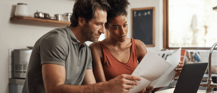 A couple reading a paycheck stub