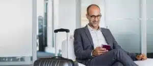 A traveler waiting at the airport with his passport in hand