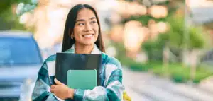 a student carrying her books and walking