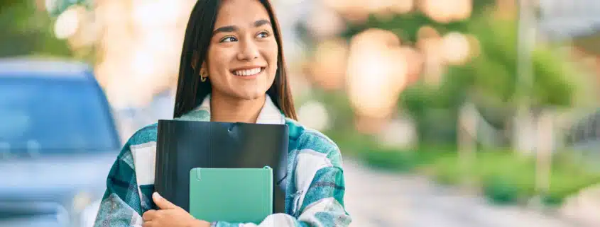 a student carrying her books and walking