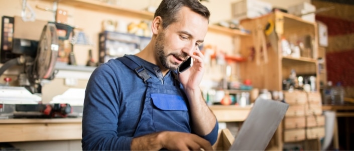 A business owner on the phone while reviewing his accounts