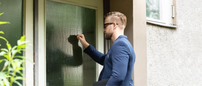 An IRS officer knocking on the door of a homeowner for a visit