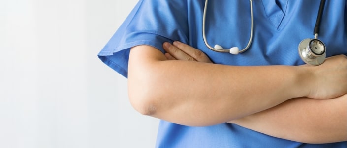 A close-up of the folded arms of a medical professional