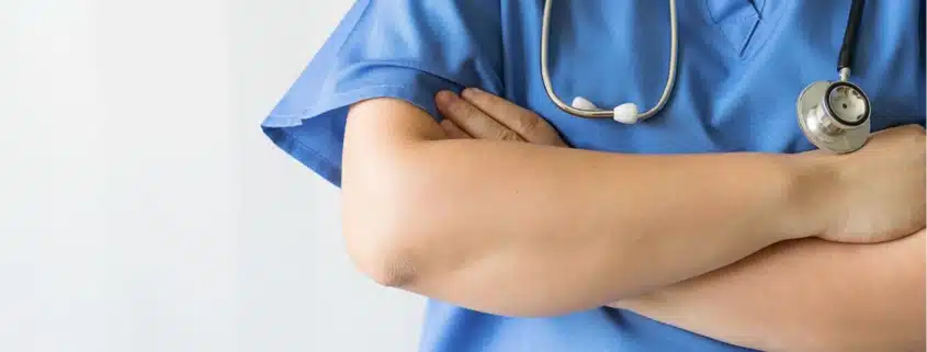 A close-up of the folded arms of a medical professional