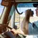A truck driver driving while talking into his radio