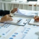 Close-up of two businesswomen calculating financial statements at a desk.